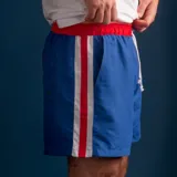Short de baño azul con cintura elástica roja y rayas verticales blancas y rojas.