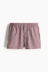 Pack de dos calzoncillos tipo boxer en tejido suave, con cintura elástica y bragueta de botones. Uno de ellos presenta un patrón a cuadros pequeños en tonos rojo y blanco, mientras que el otro cuenta con un diseño de cuadros tipo tartán en tonos rojo y negro.