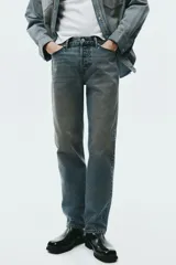 Pantalón jean de cinco bolsillos en denim de algodón rígido, con pierna recta apenas holgada y corte estándar. Cuenta con cintura clásica y cierre de botones.