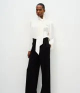 Pantalón de corte wide leg confeccionado en crepé color bordó, con cintura alta, cierre frontal con cremallera y detalle de hebilla ajustable en la cintura.