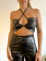 Top negro de cuero sintético con cuello halter y diseño cruzado en el frente.
