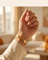 Pulsera de eslabones rectangulares planos con baño de oro, diseño minimalista y cierre integrado.