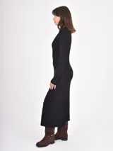 Vestido midi de punto color negro, con cuello alto y mangas largas, de corte ajustado en la parte superior y falda ligeramente acampanada.