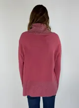 Sweater negro con cuello alto tipo drapeado y puños y dobladillo con tejido brillante en tonos grises.