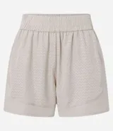 Short deportivo tipo runner de microfibra ligera, color beige claro, con textura de microperforaciones y cintura elástica fruncida.