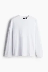 Remera blanca de punto liviano con tecnología Thermolite, de manga larga, cuello redondo ribeteado y bajo recto. Tiene un corte estándar para una silueta clásica y cómoda.