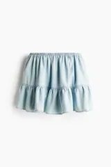 Pollera mini de denim claro con cintura elástica y diseño de volado amplio en el ruedo.