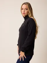 Buzo de polar con cuello alto y medio cierre frontal. Presenta un diseño de manga larga con puños elásticos y logo bordado en el pecho.