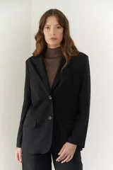 Blazer negro de poliéster, viscosa y spandex, con forro animal print, hombreras, botones frontales y en mangas.