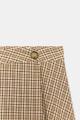 Falda midi de tiro alto con estampado de cuadros, diseño cruzado y detalle de botón en la cintura.