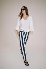 Jeans de tiro medio de corte slim, con diseño de rayas verticales a contraste en color azul marino y blanco. Cuenta con cinco bolsillos, trabillas para cinturón y cierre frontal con cremallera y botón metálico.