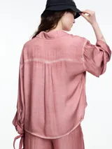 Camisa de manga larga confeccionada en viscosa teñida en frío, con efecto gastado. De corte relajado, con bolsillo delantero y puños amplios. El desgaste de color en las costuras le da un aire descontracturado.