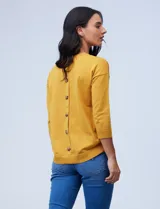 Sweater amarillo de tejido fino con espalda abotonada y mangas 3/4 con puño elastizado.