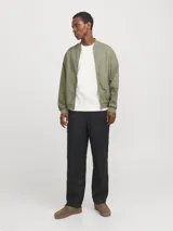 Campera bomber color verde claro, de tejido liviano de lino y algodón, con cuello tipo baseball, mangas largas con puños de canalé, cierre con cremallera y bolsillos delanteros.