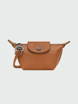 Monedero o cartera pequeña de cuero color caramelo, modelo Le Pliage Xtra, con solapa de cierre a presión con logo grabado y cierre de cremallera principal. Incluye correa fina ajustable para llevar al hombro o cruzado.