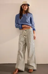 Pantalón de algodón a rayas verticales blancas y negras, de corte amplio y cintura alta con cordón ajustable.