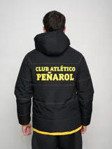 Campera de abrigo corta negra con capucha y costuras en contraste color amarillo. Estampado del escudo del Club Atlético Peñarol en el pecho y en la espalda.