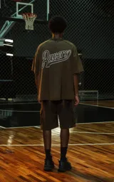 Remera de manga corta y cuello redondo, corte oversize, color marrón oscuro con efecto batik/lavado. Presenta el número "90" estampado en el pecho en un tono ligeramente más oscuro.