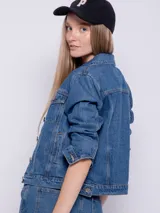 Campera de jean celeste con cuello clásico, cierre frontal con botones metálicos, mangas largas con puños abotonados, bolsillos delanteros con solapa y corte recto.