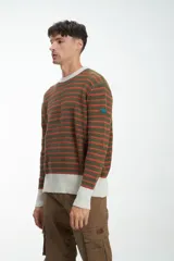 Buzo de punto a rayas horizontales color arena y azul marino, con cuello, puños y ruedo acanalados en marrón.