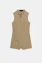 Mono corto entallado de cuello redondo y manga sisa, con cierre frontal de cremallera metálica y bolsillos delanteros con cremallera.