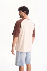 Remera oversize de manga corta raglán, color blanco con mangas y cuello en azul marino.