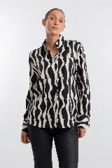 Camisa de manga larga con estampado geométrico de ondas en blanco y negro, cuello camisero y cierre frontal de botones.
