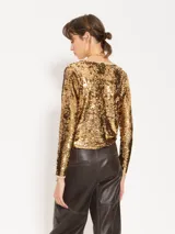 Top dorado de lentejuelas con mangas largas y cuello redondo.