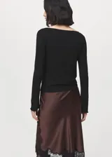 Remera negra de manga larga con cuello barco, confeccionada en tejido elástico y entallado.