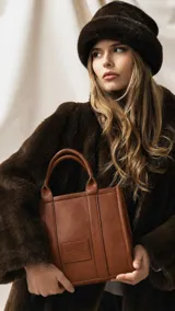 Cartera estructurada de tamaño mediano, confeccionada en símil cuero color negro. Presenta doble asa de mano, correa larga ajustable y desmontable, y un bolsillo trasero con cierre. El compartimento principal cuenta con cierre, división interna y bolsillos organizadores.
