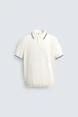 Polo de punto tejido en algodón, de corte regular fit. Presenta cuello solapa con cierre frontal de botones y manga corta, con acabados en rib y detalles de bandas a contraste en cuello y puños.