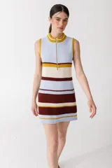 Vestido corto tejido de punto a rayas horizontales en tonos celeste, crema, marrón y mostaza. Tiene cuello alto y cierre metálico frontal. Sin mangas.