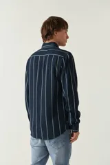 Camisa de mangas largas con estampado a rayas verticales en tonos verde oliva, blanco y azul. Corte regular y logo bordado en el pecho. Confeccionada en viscosa.