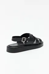 Sandalias color beige con capellada entrelazada y agarre ajustable en el talón. Plataforma de 3cm de alto y suela negra.