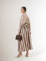 Falda midi a rayas con bolsillos laterales, cintura elastizada y lazo incorporado para ajustar en la cintura.