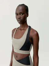 Top deportivo bicolor con asimetría, sujeción media-alta y tirantes cruzados. Confeccionado en tejido Shape_Tech con interior de mesh y copas extraíbles.