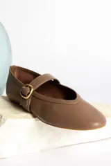 Ballerinas color marrón con correa sobre el empeine y hebilla dorada.