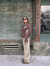 Pantalón de jean estilo barrel, color verde gastado, con tiro medio y diseño de pierna ancha con bolsillos laterales tipo cargo.