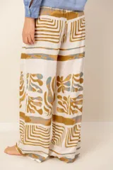 Pantalón holgado de lino blanco con estampado en tonos ocre y azul, de corte recto y cintura elástica fruncida.