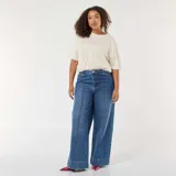Jean de corte wide leg en color azul, con talle alto y costuras verticales decorativas en el frente. Presenta un diseño de pierna ancha y ruedo recto.