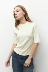 Remera de manga corta con cuello redondo, confeccionada en tejido de punto liso de color crema.