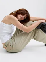 Jean de corte barrel fit con tiro medio, confeccionado en denim de sarga con un lavado teñido en tono beige. Presenta pierna suelta, cierre con bragueta y diseño de cinco bolsillos.