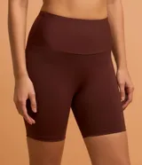 Bermuda deportiva corta color marrón, de tiro alto con cintura elástica ancha y ajuste ceñido al cuerpo.