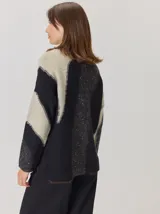 Buzo de tejido de punto con diseño de rayas verticales anchas en tonos beige y crema, cuello semipolera y manga larga.
