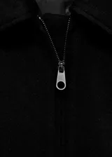 Chaqueta estilo bomber de corte recto y tejido mezcla de lana, con cuello camisero, cierre frontal con cremallera, bolsillos laterales y forro interior.