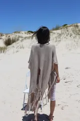 Ruana abierta de tejido de punto fino en color negro con sutiles destellos dorados, de corte holgado y mangas anchas tipo kimono.
