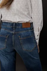 Camisa blanca de voile de algodón con bordado floral, corte clásico, cuello camisero y cierre frontal con botones. Mangas largas con puños abotonados.