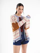Cardigan tejido de punto jacquard en tonos bordó y rojo con rayas, de corte oversize, cuello redondo y cierre frontal con botones carey. Presenta detalles bordados en contraste y monograma en la espalda.