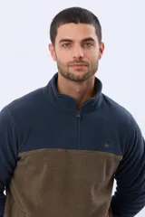 Buzo de polar texturado con diseño bicolor en azul marino y marrón, cuello alto con medio cierre y bolsillos laterales.