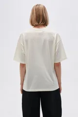 Remera oversize de algodón color gris oscuro, con cuello redondo, mangas cortas y estampado lateral en tonos claros de cadenas y una llave.